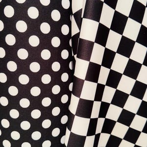 May include: Black and white fabric with a polka dot pattern on one side and a chequered pattern on the other side.