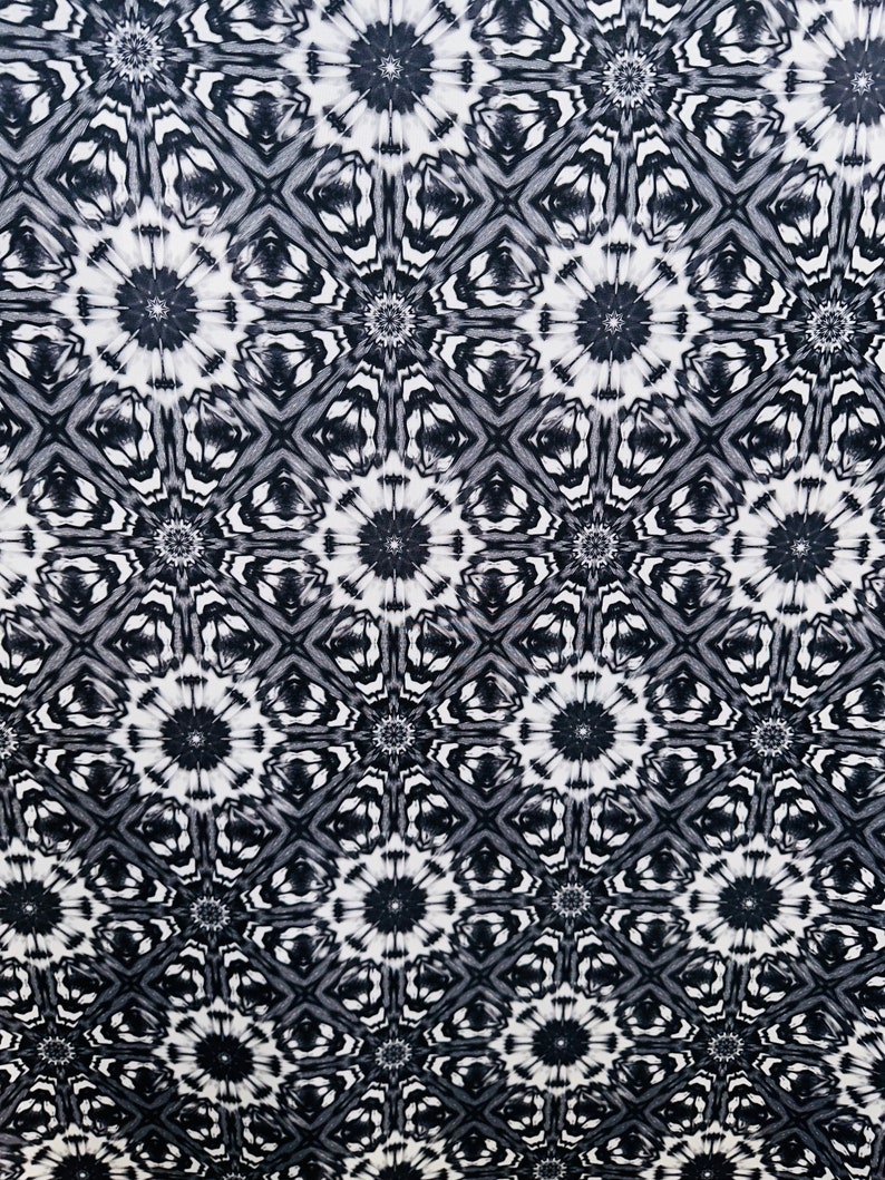 May include: Black and white abstract pattern with a repeating geometric design. The pattern features a series of interlocking circles and squares.