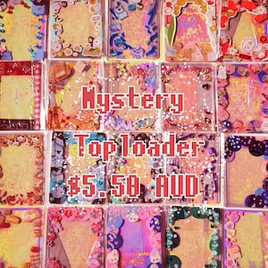 May include: A collection of 16 colourful, glittery, and decorated top loaders for trading cards. The top loaders are arranged in a grid pattern and feature various designs, including hearts, stars, and glitter. The text "Mystery Top Loader $5.50 AUD" is displayed in the centre of the image.