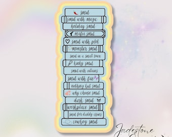 May include: A sticker with a stack of books, each book has a different type of smut written on it. The sticker is on a light blue background with a yellow border. The text on the sticker reads: "Smut", "Smut with magic", "Holiday Smut", "Mafia Smut", "Smut with plot", "Monster Smut", "Smut in a small town", "Kinky Smut", "Smut with villains", "Smut with fae", "Nothing but Smut", "Why choose Smut", "Dark Smut", "Workplace Smut", "Smut for daddy issues", "Cowboy Smut". The sticker also has a small image of a chili pepper, a gun, a heart, a book, a feather, a flower, two hearts, a skull, a briefcase, a cowboy hat, and the text "Jadestone Creates".
