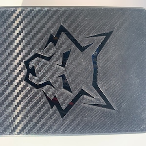 May include: A black rectangular box with a carbon fiber pattern and a cut-out wolf head logo.