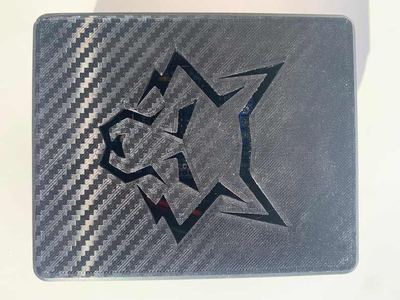 May include: A black rectangular box with a carbon fiber pattern and a cut-out wolf head logo.