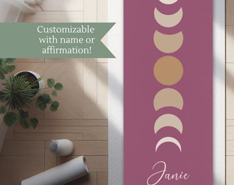 May include: A purple yoga mat with a design of a crescent moon in different phases. The mat has the name "Janie" printed on it.