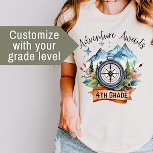 May include: A white t-shirt with a compass and mountains graphic. The text "Adventure Awaits" is above the graphic and "4th Grade" is below the graphic.