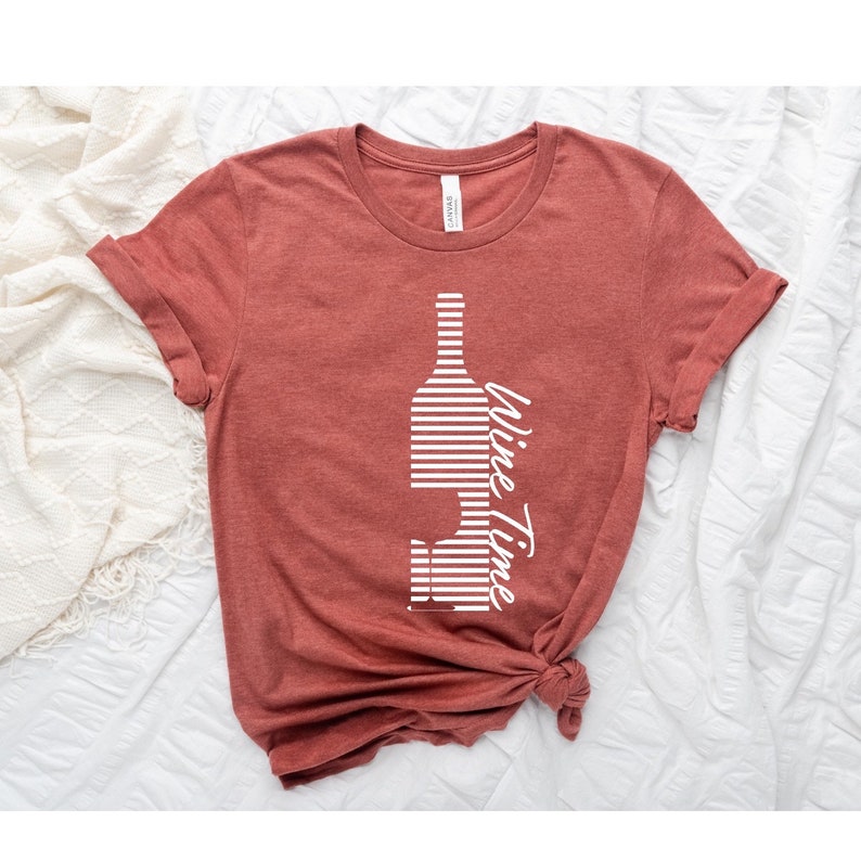 May include: A rust-colored t-shirt with a white striped wine bottle graphic and the text "Wine Time" printed on the front.