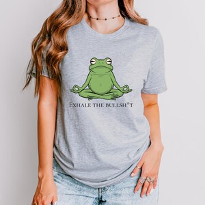 May include: A gray t-shirt with a green frog meditating and the text "Exhale the Bullsh*t".