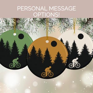May include: Three circular Christmas tree decorations with a cyclist silhouette design. Each decoration has a different background colour: green, gold, and cream. The decorations feature a black forest silhouette and a cyclist. The text "PERSONAL MESSAGE OPTIONS!" is at the top.