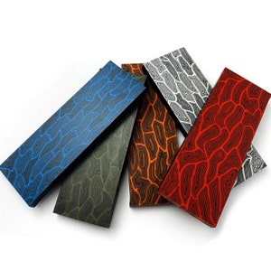 May include: Five different patterned sheets of colorful, decorative, wood-like material. The sheets are arranged in a fan shape, with the blue sheet at the top and the red sheet at the bottom.