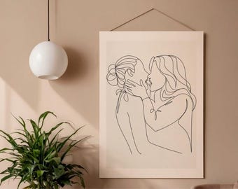 May include: A rectangular wall art print featuring a black continuous line drawing of two figures embracing and kissing. The artwork is displayed on a light beige background and is suspended by a thin cord from the top edge of the frame.