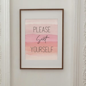 Puede incluir: Una impresión enmarcada con un fondo de acuarela en tonos de rosa y naranja. El texto "PLEASE Seat YOURSELF" está escrito en negro.
