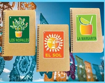 May include: Three brown spiral notebooks with colorful stickers. The stickers feature a cactus, a sun, and a margarita. The notebooks are labeled "Los Nopales", "El Sol", and "La Margarita".