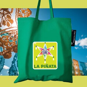 May include: A green tote bag featuring a colorful piñata design on a yellow square. The piñata is star-shaped with multiple colors and the text "LA PIÑATA" below. The bag has a tag that says "Designed 4 u n Mind".