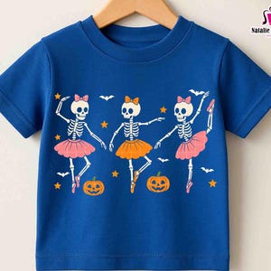 Puede incluir: Una camiseta azul de manga corta con un dise&ntilde;o de Halloween. El gr&aacute;fico muestra tres bailarinas esqueleto con tut&uacute;s rosas y naranjas, con calabazas, murci&eacute;lagos y estrellas. El texto "Only PNG" est&aacute; en la esquina superior izquierda.