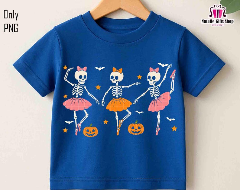 Puede incluir: Una camiseta azul de manga corta con un dise&ntilde;o de Halloween. El gr&aacute;fico muestra tres bailarinas esqueleto con tut&uacute;s rosas y naranjas, con calabazas, murci&eacute;lagos y estrellas. El texto "Only PNG" est&aacute; en la esquina superior izquierda.