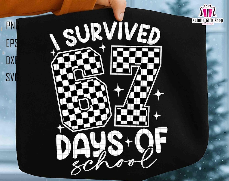 May include: Black tote bag with the text "I Survived 67 Days of School" in white. The numbers "67" are checkered. The bag is held by a person.