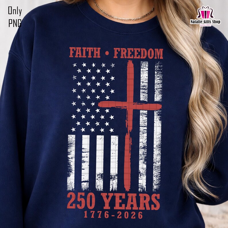 Op de afbeelding: Marineblauw sweatshirt met een verweerd Amerikaans vlagontwerp en een rood kruis. De tekst luidt "FAITH &bull; FREEDOM" en "250 YEARS 1776-2026" in het rood. De trui heeft een ronde hals en lange mouwen.