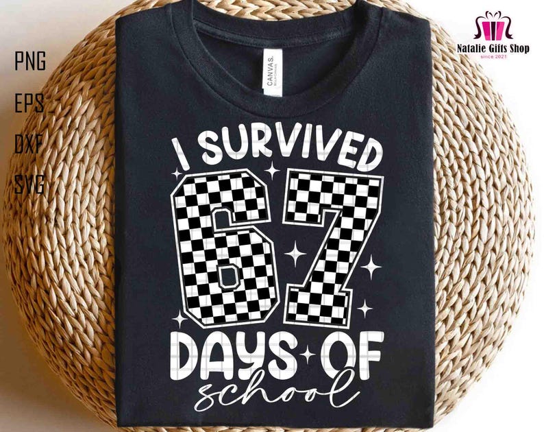 May include: Black t-shirt with the text "I Survived 67 Days of School" in white. The numbers "67" are designed with a black and white checkered pattern. The shirt is displayed on a woven surface.