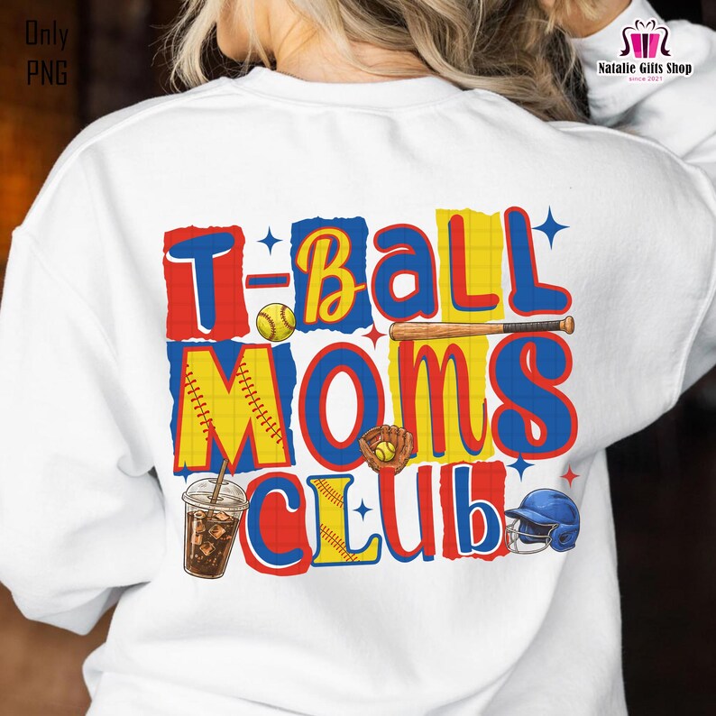 May include: White sweatshirt with a colorful graphic that reads "T-Ball Moms Club." The design includes baseball-themed illustrations such as a baseball, bat, glove, and helmet. The text is in red, yellow, and blue.