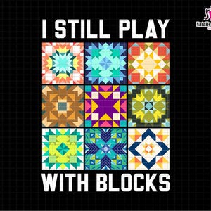 May include: A colorful graphic design with the text "I Still Play With Blocks". The design features nine colorful quilt blocks with geometric patterns.