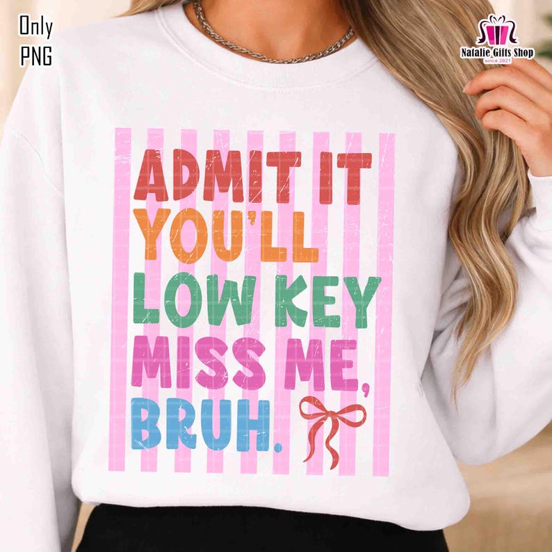 May include: White sweatshirt with the text "ADMIT IT YOU'LL LOW KEY MISS ME, BRUH." in various colors. The text is set against a background of pink vertical stripes. A red bow is at the bottom right.