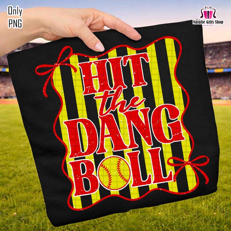 Może przedstawiać: Czarna grafika o tematyce baseballowej z napisem "HIT the DANG BALL" w kolorze czerwonym, obrysowanym na ż&oacute;łto. Projekt zawiera piłkę do baseballu oraz ż&oacute;łto-czarne paski. Czerwone kokardy zdobią krawędzie.