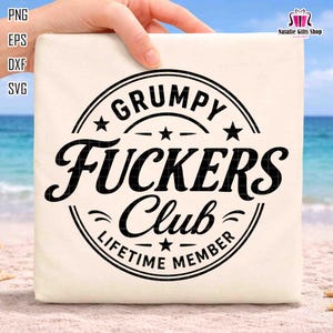 May include: A beige tote bag with the text "GRUMPY FUCKERS Club LIFETIME MEMBER" in a black, circular design. The design includes stars and curved lines. The bag is held by a hand.