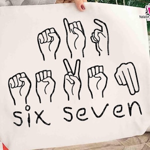 Könnte beinhalten: Eine weiße Tragetasche mit schwarzen Strichzeichnungen von Handgesten, die Zahlen in der deutschen Gebärdensprache darstellen. Die Wörter "SIX" und "SEVEN" sind in schwarzer Schrift darunter geschrieben. Die Tasche hat ein Shop-Logo.