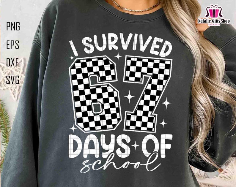 May include: Dark grey sweatshirt with the text "I Survived 67 Days of School" in white. The numbers "67" are filled with a black and white chequered pattern. The sweatshirt also has the text "DAYS OF school" in a script font.