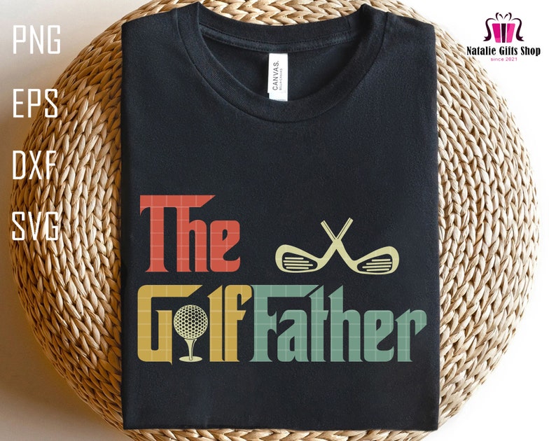 Op de afbeelding: Een zwart T-shirt met de tekst "The Golf Father" in een retro stijl met een golfbal en gekruiste golfclubs.