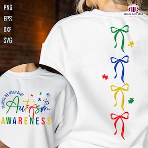 May include: White sweatshirt with the text "IN APRIL WE WEAR BLUE Autism AWARENESS" in various colors. The back features colorful bow and puzzle piece designs. The Natalie Gifts Shop logo is visible.