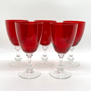 May include: Set of six red wine glasses with clear stems and bases. The glasses are made of glass and have a classic design.