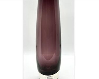 May include: A tall, elegant vase with a deep purple hue. The glass vase has a silver-colored base. The vase is a decorative item, suitable for displaying flowers or as a standalone accent piece.
