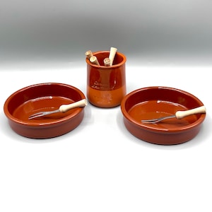 May include: Two terracotta dipping bowls with wooden dipping forks and a terracotta jar with wooden sticks inside. The jar is labeled "Sucrey Sabores".