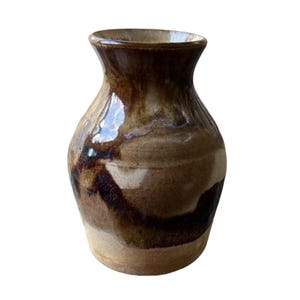 May include: A brown and white ceramic vase with a rounded body and a narrow neck. The vase has a mottled glaze with brown and white streaks.