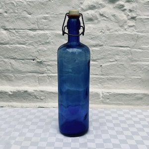 Botella vintage de vidrio azul cobalto de 29 cm con tapón abatible para boticario, refresco o decoración.