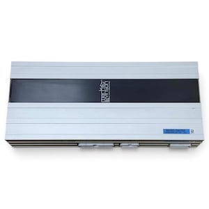 Puede incluir: Un amplificador de audio rectangular Mark Levinson con carcasa metálica plateada y un panel central negro horizontal. La unidad muestra el logotipo de la marca y el número de pieza 86280-0W250 en una etiqueta azul, con tres conectores blancos visibles en la base.