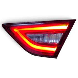 Pode incluir: Um conjunto de luz traseira automotiva triangular com uma carcaça externa vermelha brilhante e faixas de luz LED integradas que brilham em um tom vibrante de vermelho alaranjado. A seção central contém uma lente transparente texturizada.