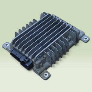 May include: A rectangular automotive electronic control unit featuring a silver-coloured metal heat sink with parallel cooling fins. The device includes a black plastic electrical connector port on one side and four mounting tabs with circular holes.