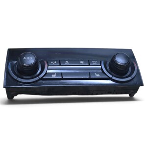 May include: A black automotive climate control panel featuring two large circular dials on the left and right sides. The center console includes buttons labeled AUTO, OFF, MAX A/C, and icons for air distribution and heated seats in a rectangular layout.