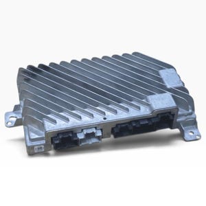 May include: A rectangular silver-coloured electronic control module featuring a series of parallel cooling fins across the top surface. The unit includes black and light grey plastic connector ports on the front edge and metal mounting tabs.