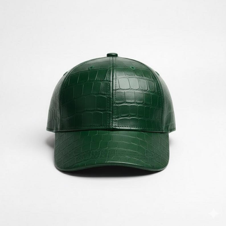 May include: A dark green baseball cap with a textured, crocodile-like pattern. The cap has a curved brim and a small button on top. The hat is made of a shiny material and is set against a white background.