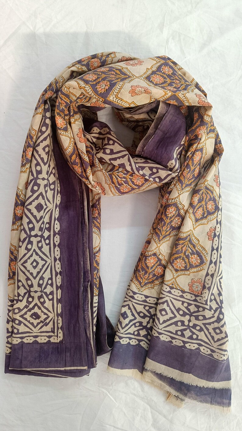 Close-up detail of a handmade block print pareo showing the intricate wooden stamp textures and soft weave of high-quality organic cotton fabric in a bohemian botanical design.