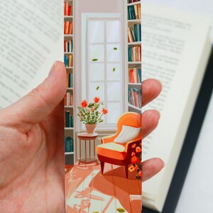 May include: A bookmark featuring a colourful illustration of a cosy reading nook with a bookshelf, a window, an orange armchair, and a potted plant. The bookmark is perfect for book lovers and adds a touch of whimsy to any book.