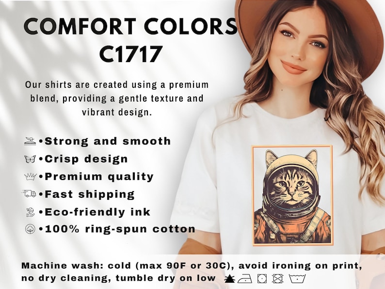 May include: White t-shirt with a framed illustration of a cat in an astronaut helmet. The text "COMFORT COLORS C1717" is at the top. The shirt is described as strong, smooth, and made with eco-friendly ink and 100% ring-spun cotton.