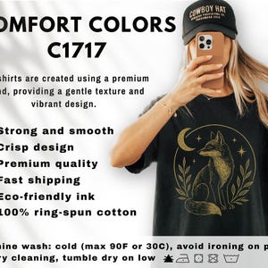 K&ouml;nnte beinhalten: Schwarzes T-Shirt mit goldener Illustration eines Fuchses, Mondes und Sternen. Das Shirt tr&auml;gt den Text "COMFORT COLORS C1717". Das Shirt besteht aus 100 % ringgesponnener Baumwolle.
