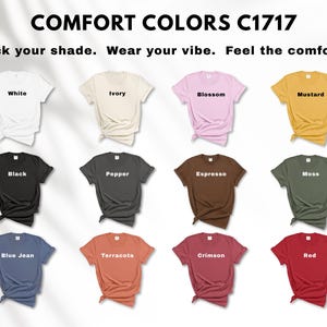 May include: A display of Comfort Colors C1717 t-shirts in various colors, including white, ivory, blossom, mustard, black, pepper, espresso, moss, blue jean, terracotta, crimson, and red. The text "Pick your shade. Wear your vibe. Feel the comfort." is at the top.