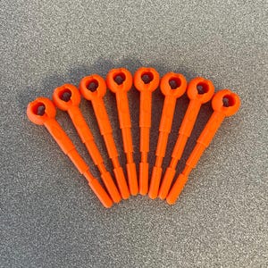 Puede incluir: Ocho herramientas de plástico naranja brillante, cada una con un lazo en un extremo y un mango delgado y estriado, dispuestas en forma de abanico sobre una superficie gris moteada. Las herramientas parecen nuevas.