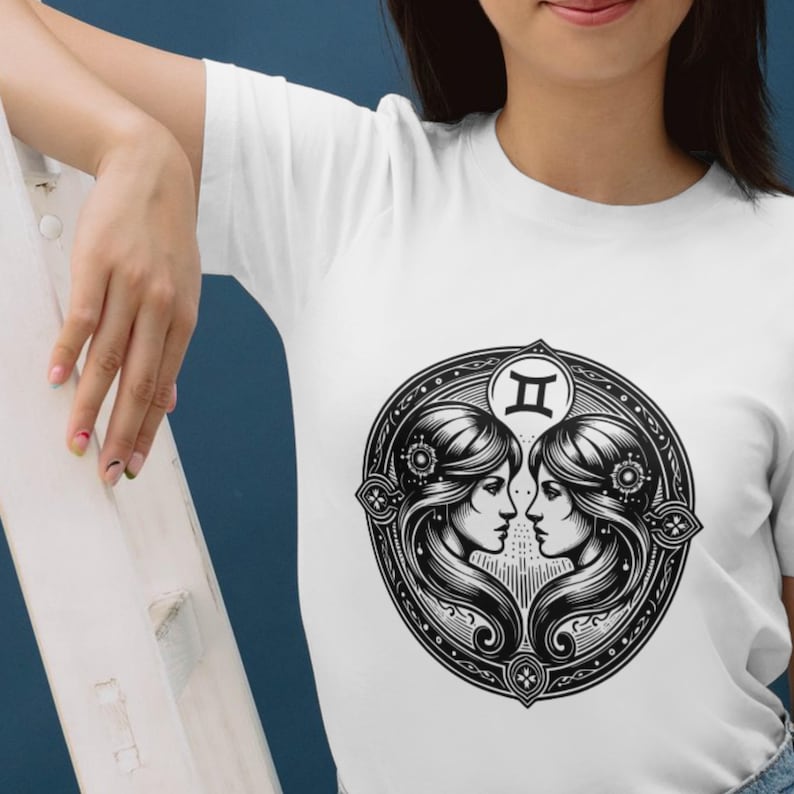 May include: White t-shirt with a black and white illustration of the Gemini zodiac sign. The illustration features two women facing each other with their heads touching. The sign "II" is above their heads.