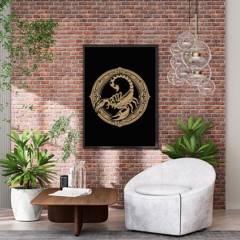 May include: A black and gold framed print of a scorpion in a circle with ornate details. The print is hanging on a brick wall with a white armchair and a wooden coffee table in front of it.