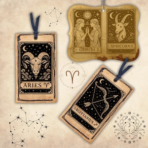 May include: Four vintage-style zodiac sign cards with black and gold illustrations. The cards feature Aries, Gemini, Sagittarius, and Capricorn. Each card has a black background with gold stars and a crescent moon.